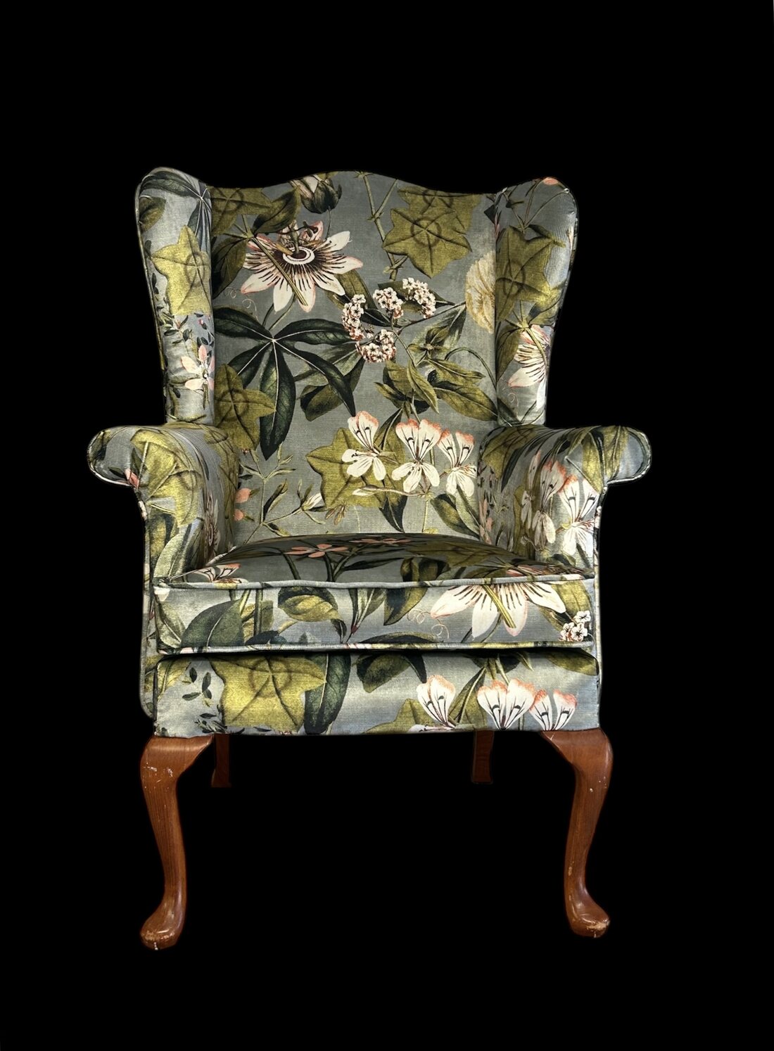 A wing-back armchair in botanical passionflower velvet