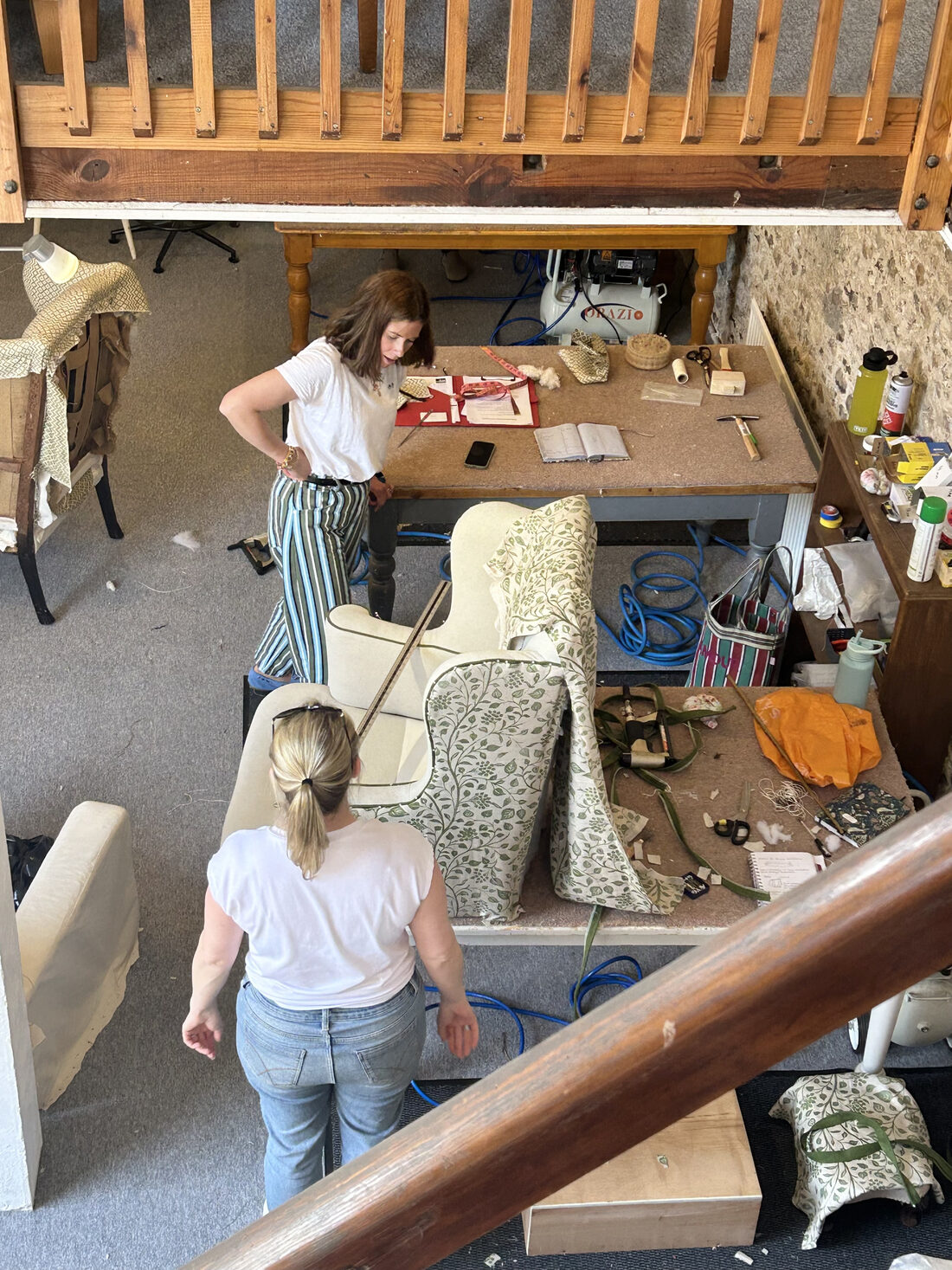 Dawn teaching a student at a wing chair being reupholstered